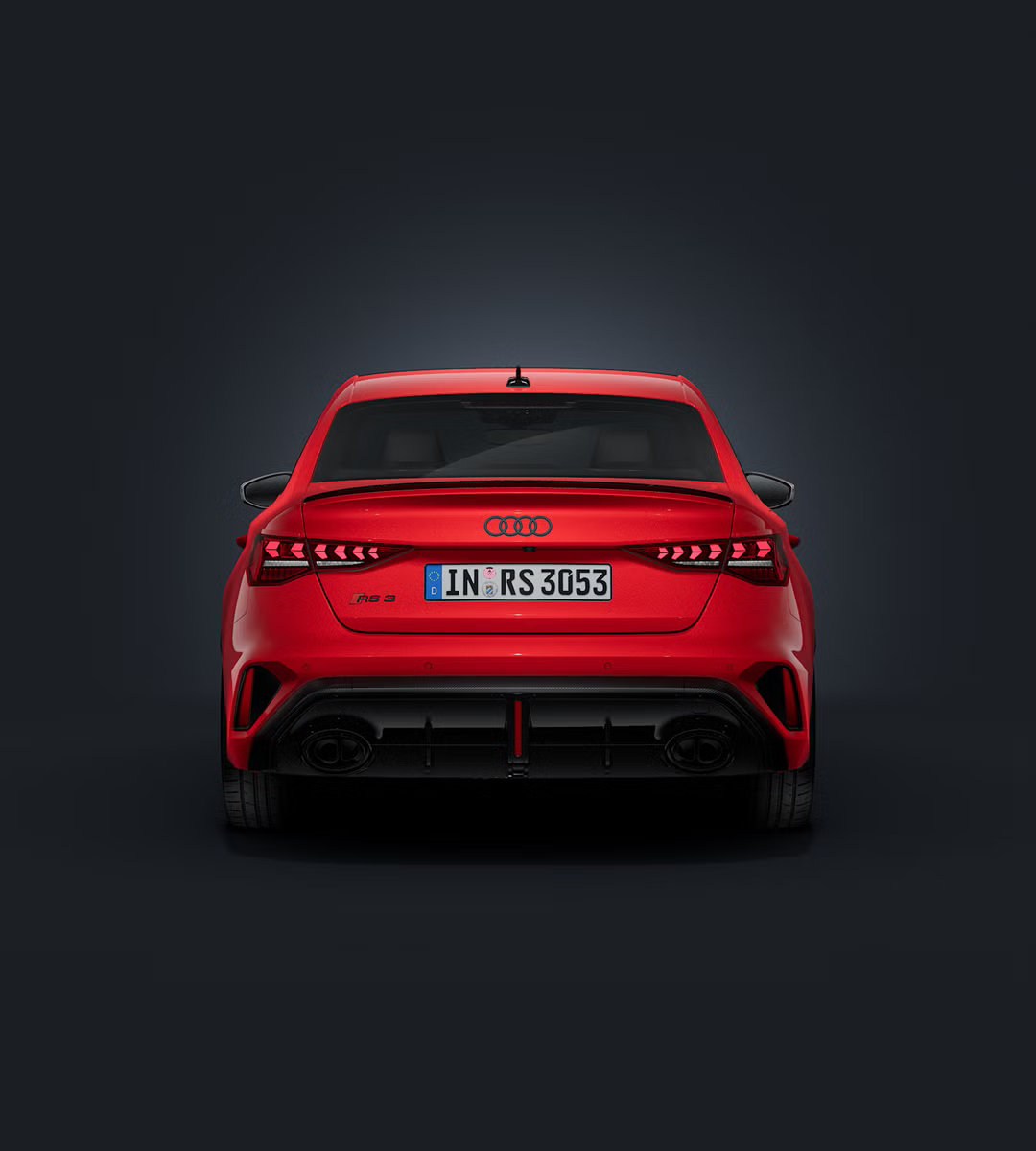 Die Audi RS 3 Limousine frontal von hinten auf dunklem Hintergrund.