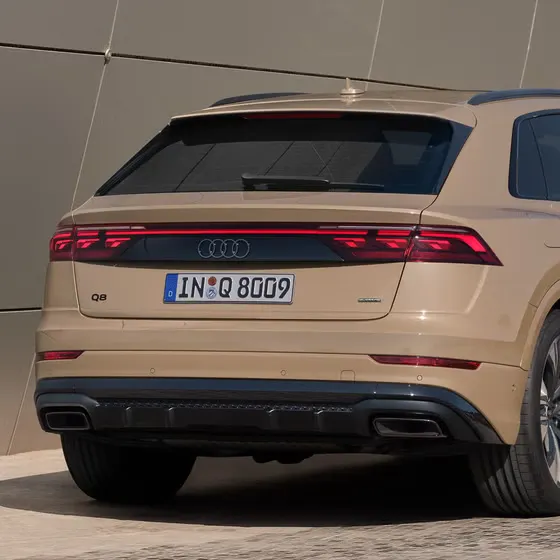 Der Q8 SUV schräg von hinten parkt vor einem modernen Gebäude. Nahaufnahme des Hecks.