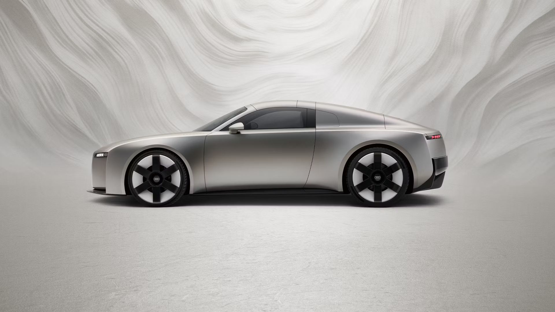 Vedere laterală a unui Audi Concept C în fața unui fundal grafic