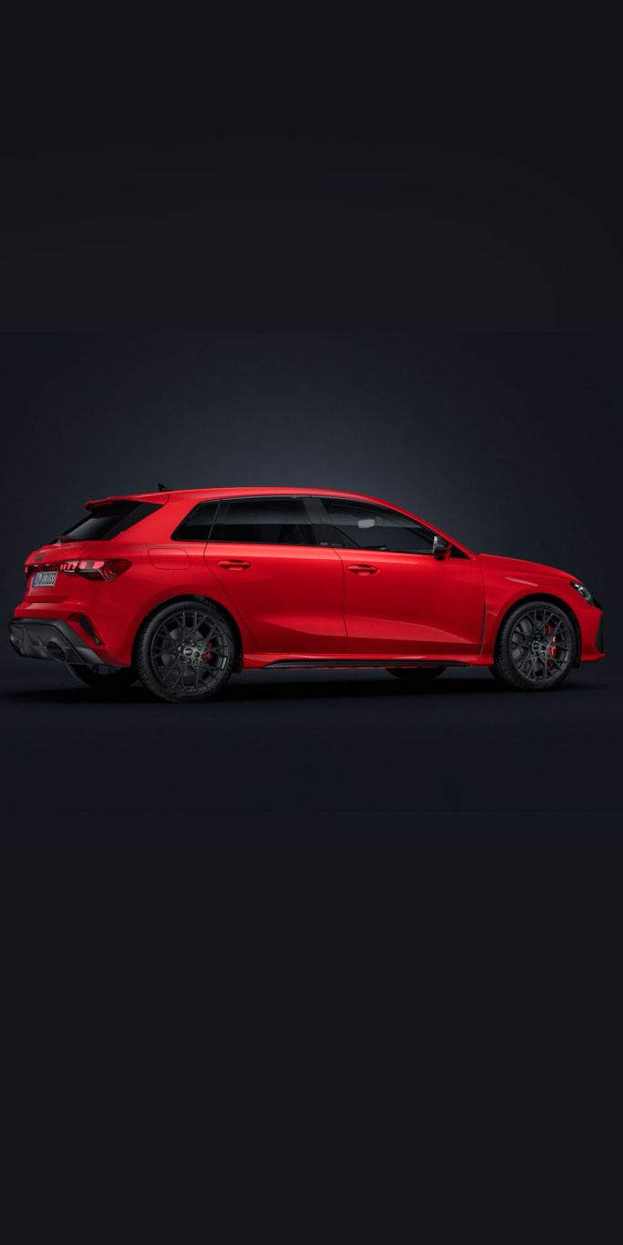 Der Audi RS 3 Sportback steht auf dunklem Hintergrund und dreht sich leicht auf die rechte Seite.