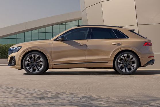 Der Audi Q8 SUV von der Seite, parkend vor einem futuristischem Gebäude.