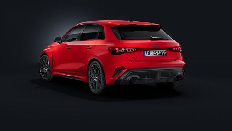 Der Audi RS 3 Sportback schräg von hinten auf dunklem Hintergrund.