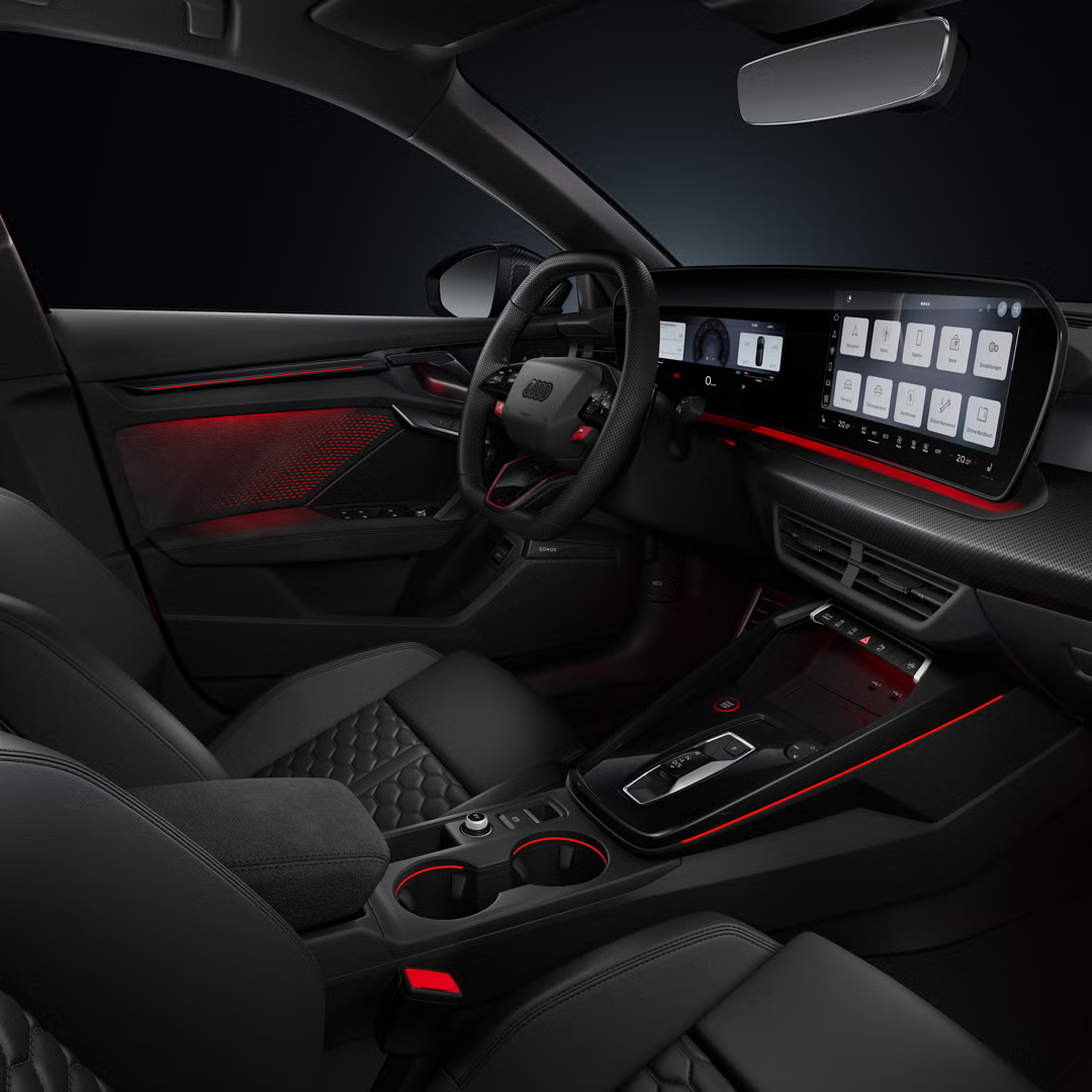 Seitlicher Blick auf das Cockpit mit Sportkonturlenkrad, das geschwungene Panoramadisplay und das Ambiente-Licht.
