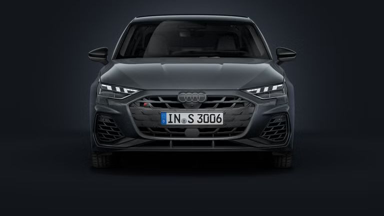 Die Audi S3 Limousine frontal von vorn auf dunklem Hintergrund.