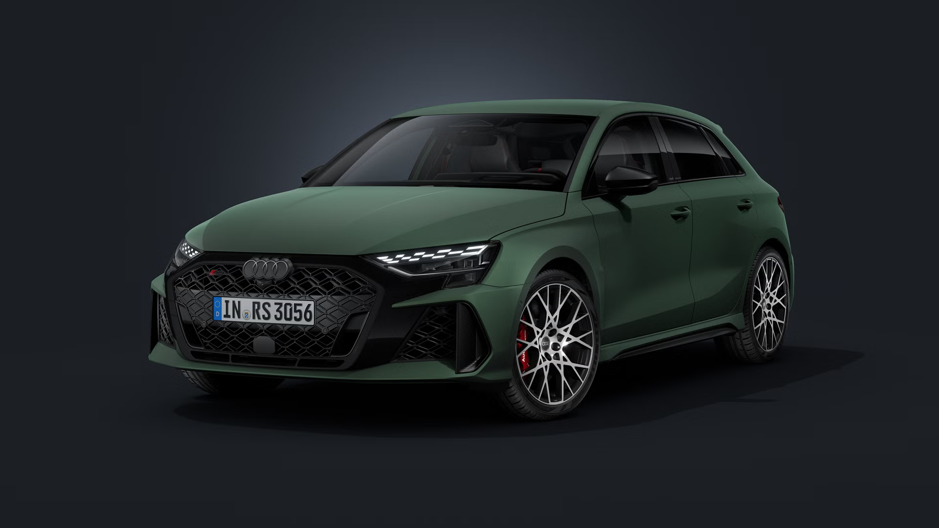 Der Audi RS 3 Sportback mit Lackierung Distriktgrün Polarmatteffekt-Lackierung schräg von vorn auf dunklem Hintergrund.