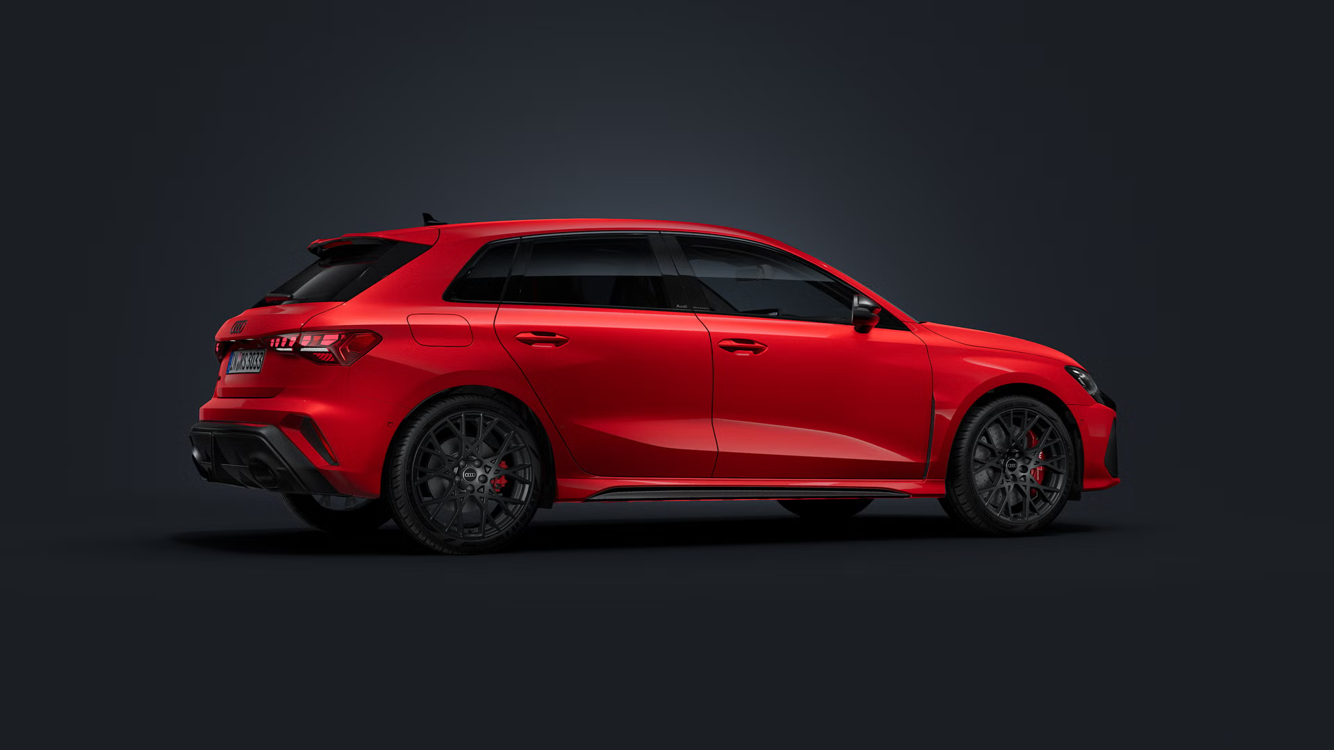 Der Audi RS 3 Sportback steht auf dunklem Hintergrund und dreht sich leicht auf die rechte Seite.