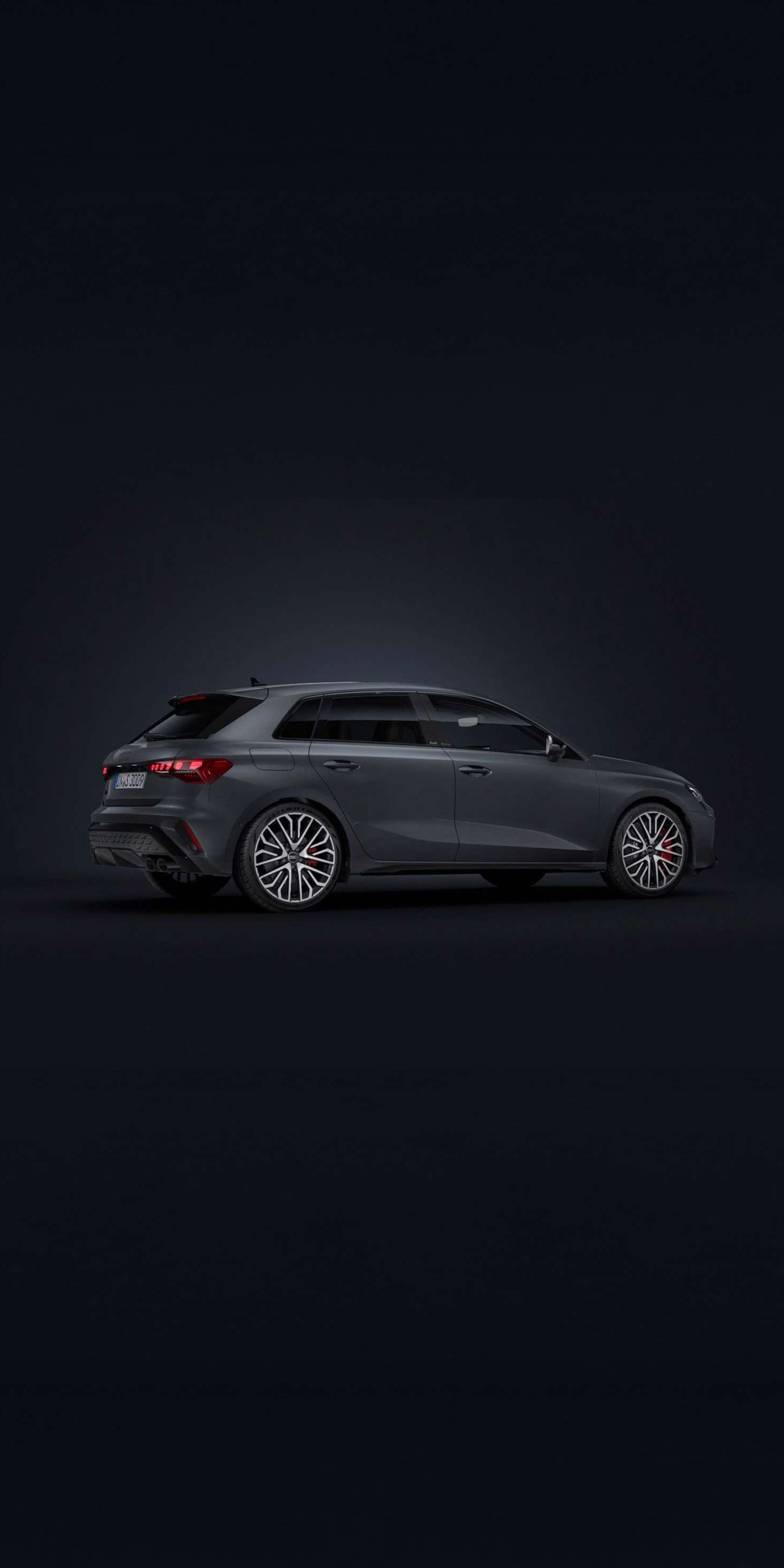 Der Audi S3 Sportback steht auf dunklem Hintergrund und dreht sich leicht auf die rechte Seite.