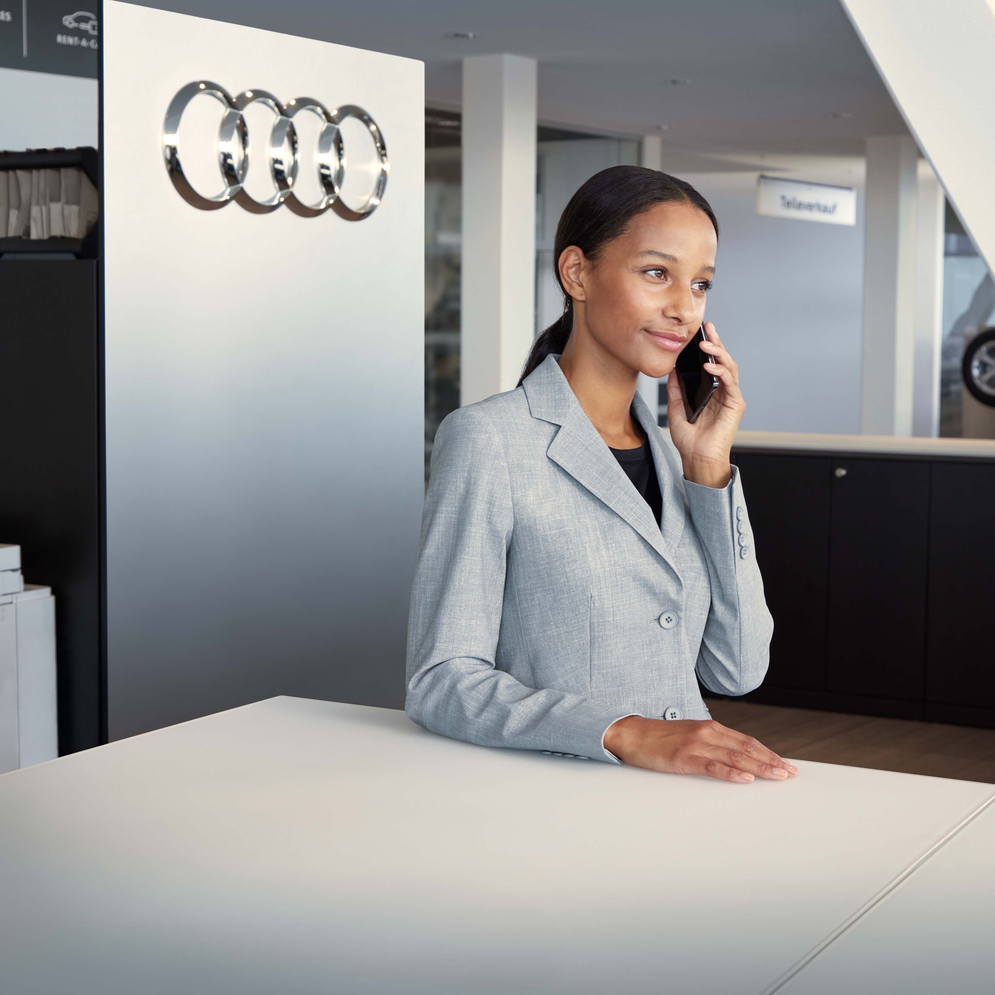 Kundenbetreuerin an der Rezeption mit Smartphone