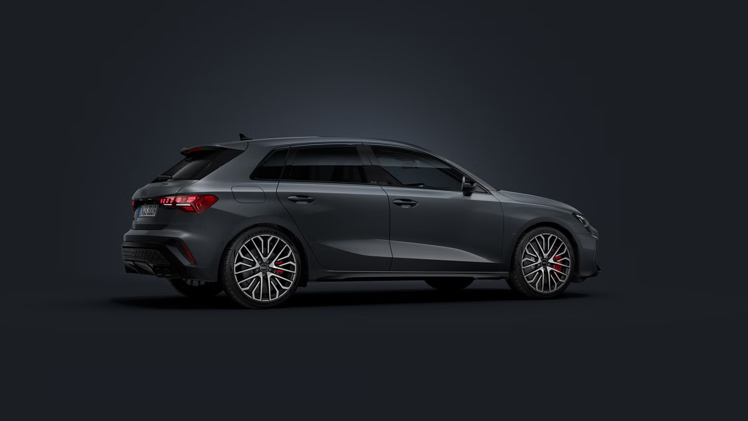 Der Audi S3 Sportback steht auf dunklem Hintergrund und dreht sich leicht auf die rechte Seite.