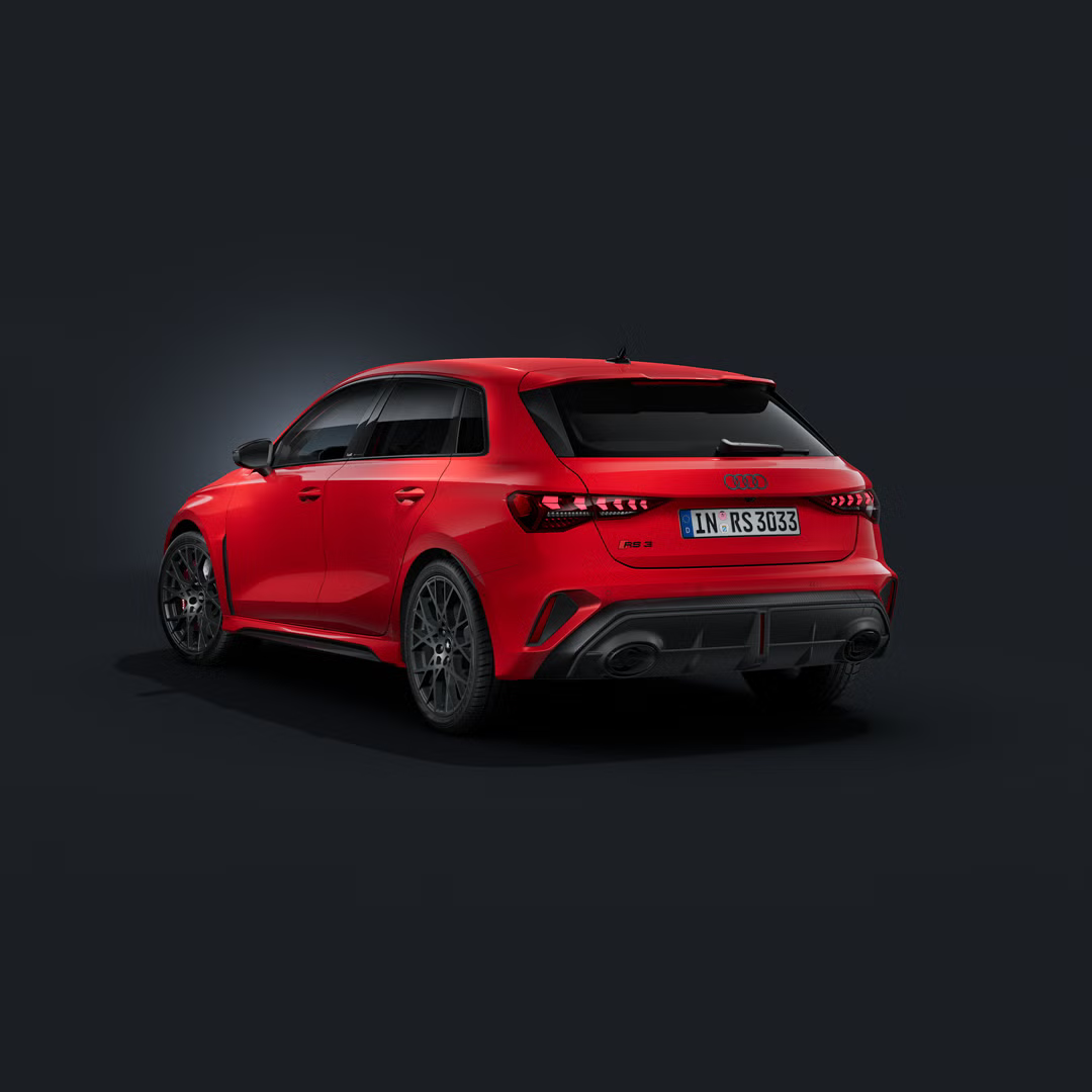 Der Audi RS 3 Sportback schräg von hinten auf dunklem Hintergrund.