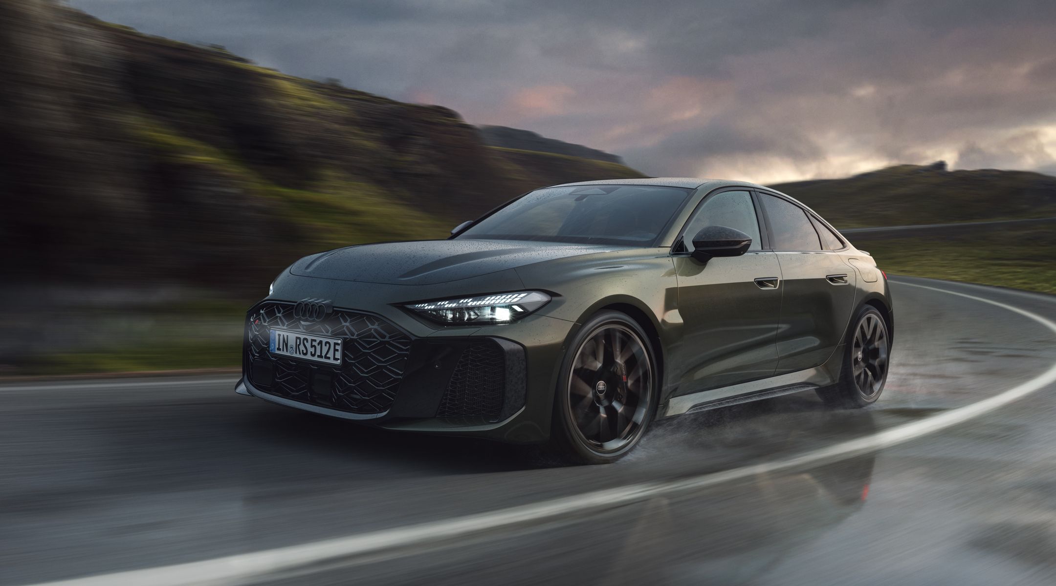 RS 5 Limuzină, surprinsă din unghi frontal, în timp ce abordează o curbă pe un drum montan.