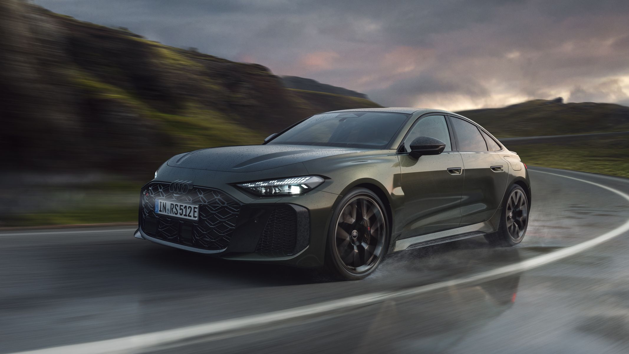 RS 5 Limuzină, surprinsă din unghi frontal, în timp ce abordează o curbă pe un drum montan.