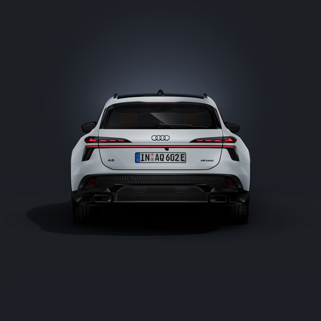 Der Audi A6 allroad e-hybrid frontal von hinten auf dunklem Hintergrund.