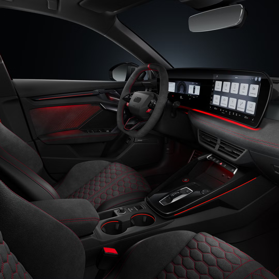 Blick von der Beifahrerseite auf das Cockpit mit Sportkonturlenkrad, Mittelkonsole, digitale Displays und das Ambiente-Licht.