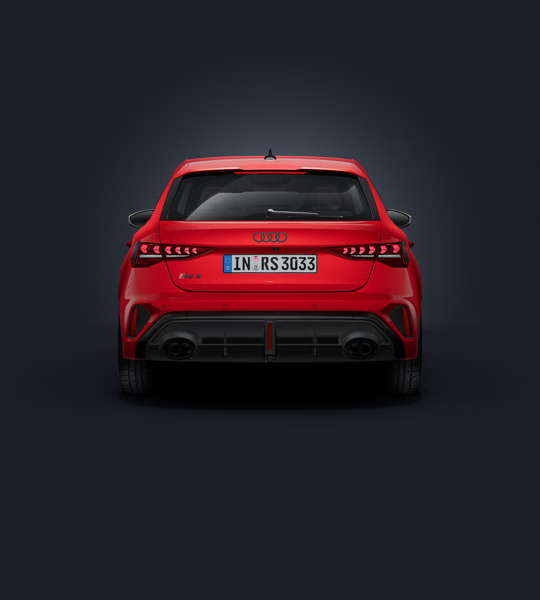 Der Audi RS 3 Sportback frontal von hinten auf dunklem Hintergrund.